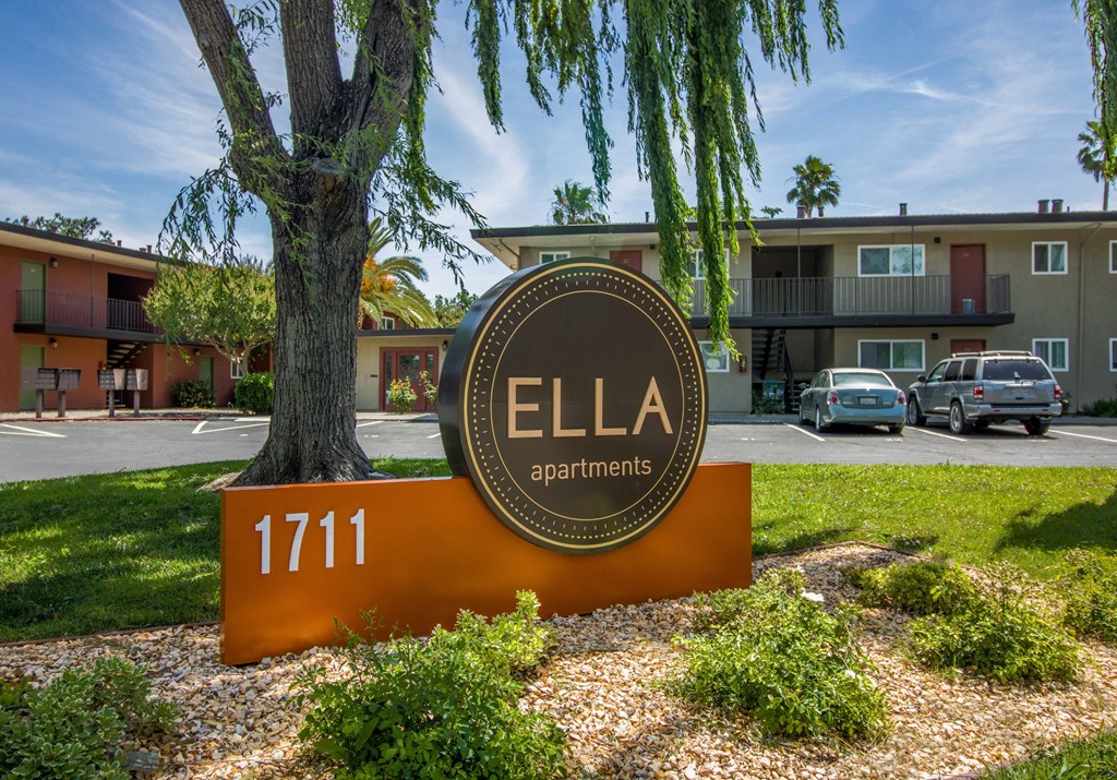 a sign that says apartments in front of a tree at Ella 1711 Apartments, Woodland, CA 95695