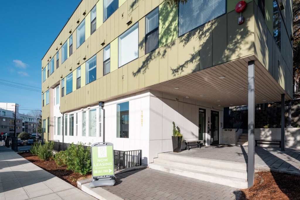 the front of a building with stairs and a green sign in front at Enve, Seattle, 98102