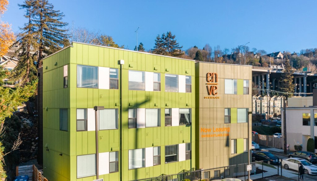 a green and yellow building with trees in the background at Enve, Seattle Washington