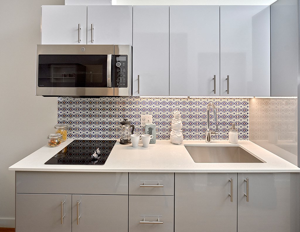 a kitchen with white cabinets and a sink and a microwave at Enve, Seattle Washington