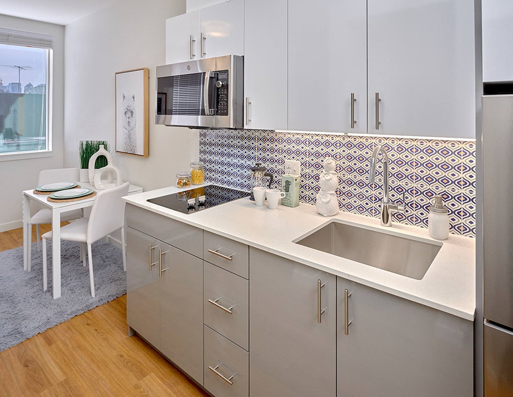 a kitchen with stainless steel appliances and a sink and a microwave at Enve, Seattle, WA