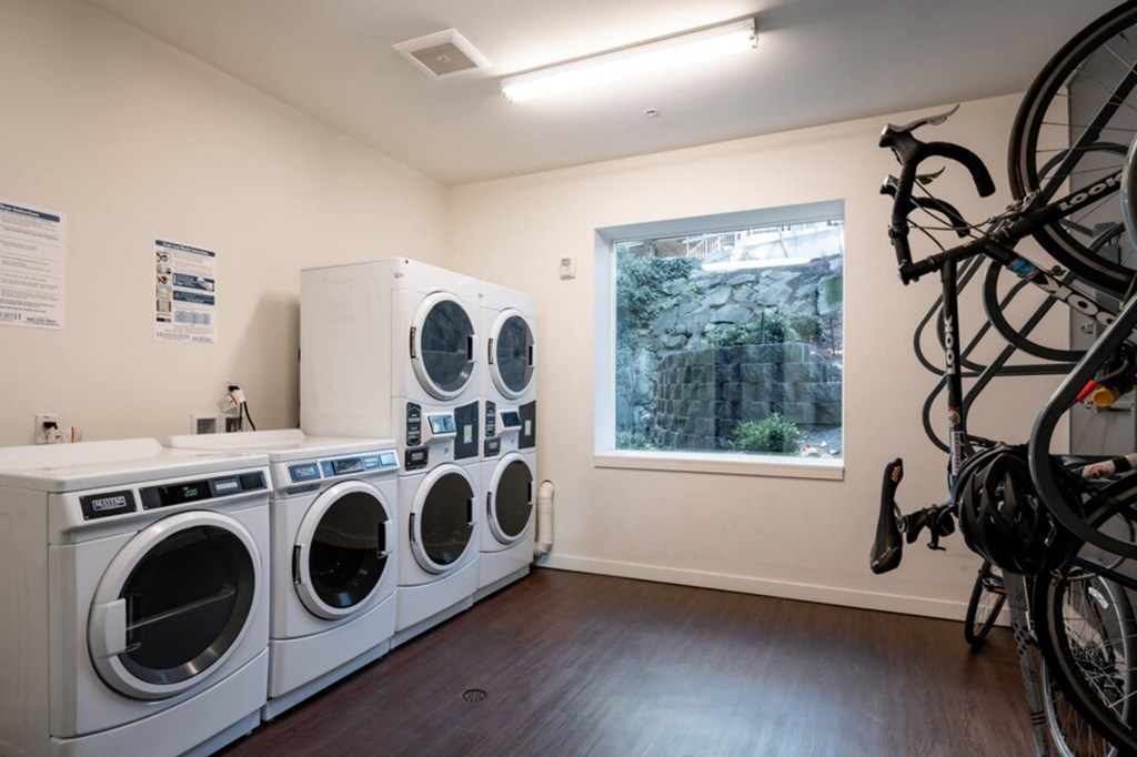 a laundry room with washing machines and bicycles on the wall at Enve, Seattle, 98102