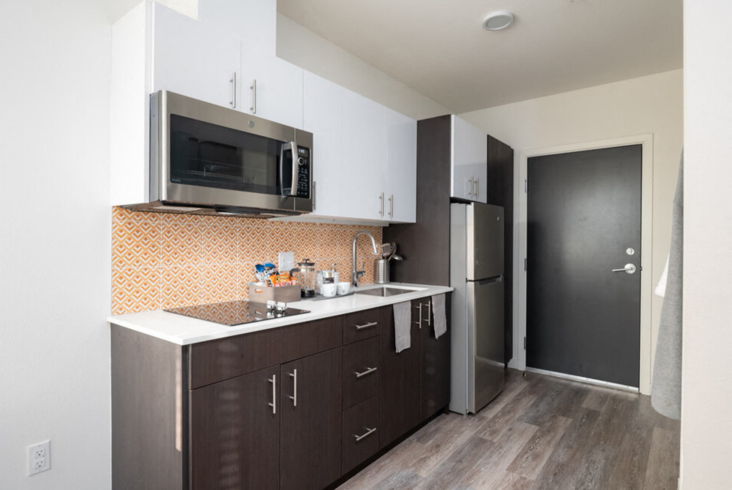 a kitchen with a sink and a microwave and a refrigerator