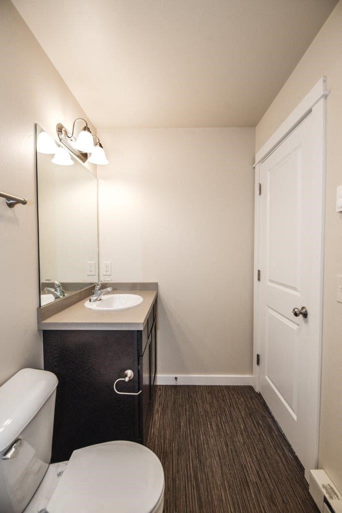 a bathroom with a toilet and a sink and a mirror at Madison Park, Bozeman, 59718