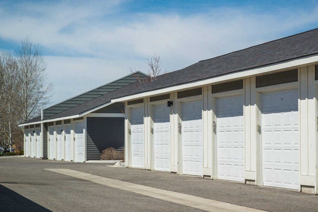 a row of white garages with white doors at Madison Park Apartments in Bozeman, MT
