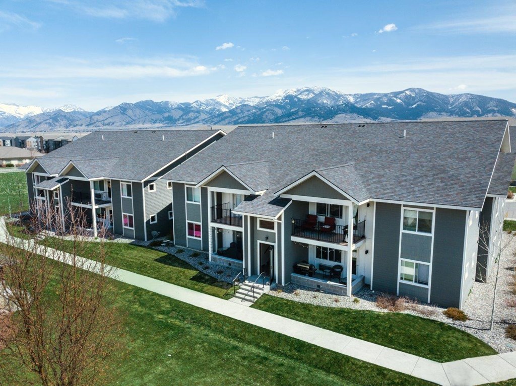 an aerial view of three houses with mountains in the background at Madison Park, Montana, 59718