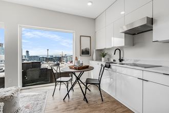 an open kitchen with a table and chairs and a window overlooking the city