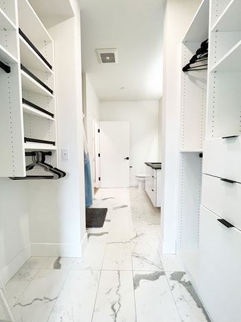a walk in closet with white cabinets and a white marble floor  at Oslo, Washington