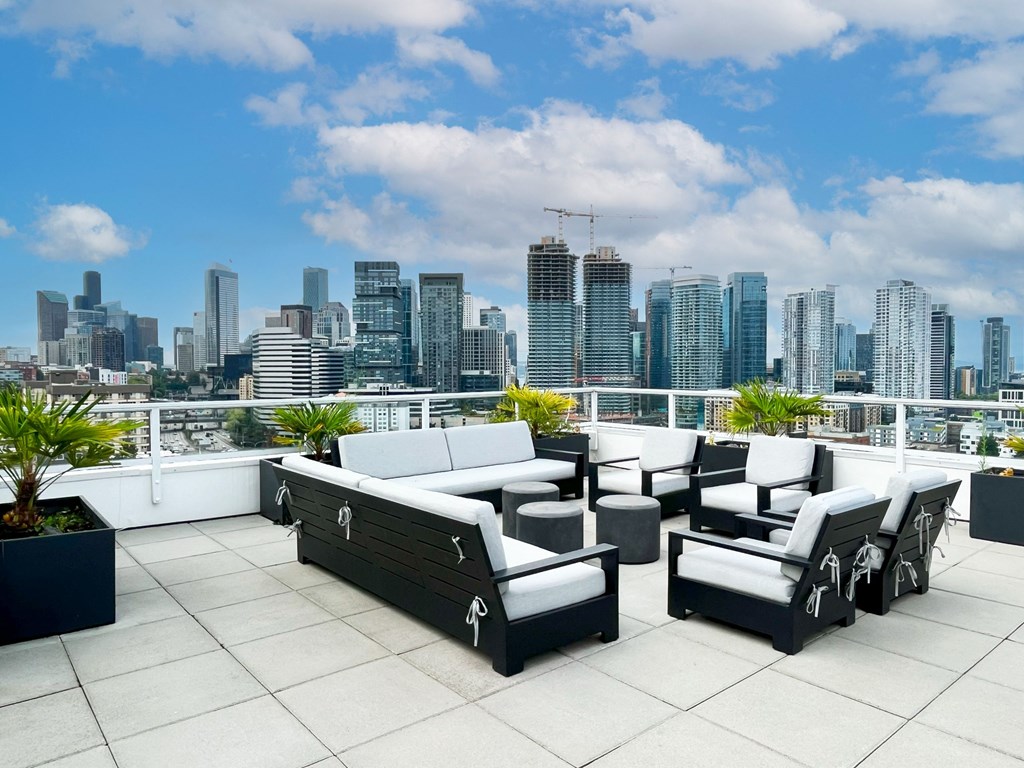 a terrace with a view of a city and a patio with furniture  at Oslo, Seattle, WA