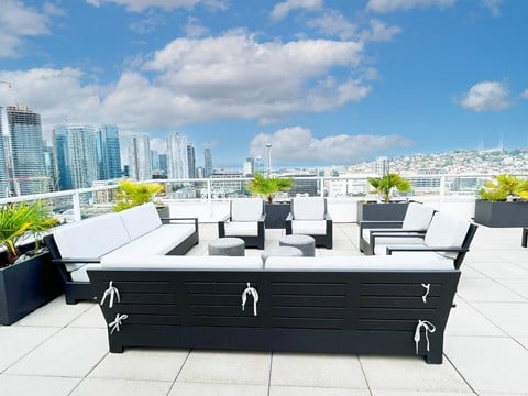 a lounge area on the roof of a building with a city in the background  at Oslo, Seattle, 98102