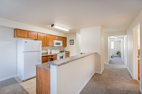 a long kitchen with white appliances and a granite counter top  at Quail Springs, West Richland, WA, 99353