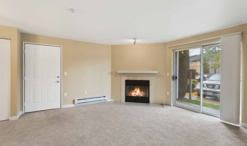 an empty living room with a fireplace and a glass door at Quartz Creek, Mountlake Terrace, Washington