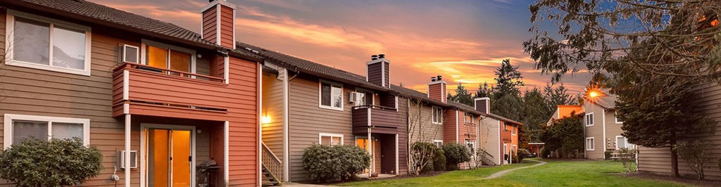 a row of houses with a sunset in the background at Quartz Creek, Mountlake Terrace, WA, 98043