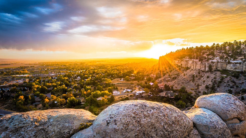 a view of the sunset over a city from a rocky hill at Rock Creek, Billings, MT