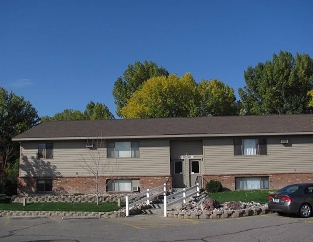 a tan house with a car parked in front of it at Rock Creek, Billings