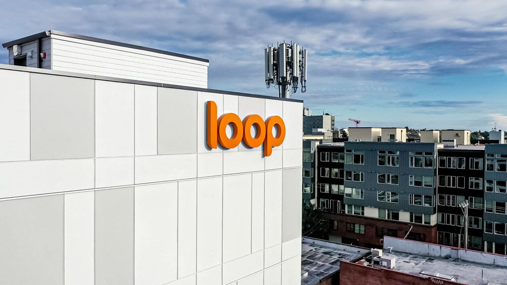 the logo of the company is on the side of a building at The Loop at Green Lake, Seattle, WA, 98115