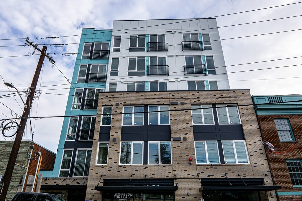 a tall apartment building with a blue and brick facade at The Loop at Green Lake, Seattle, WA, 98115