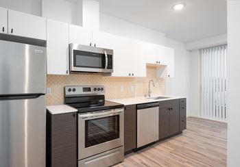 a kitchen with stainless steel appliances and white cabinets at The Loop at Green Lake, Seattle, 98115