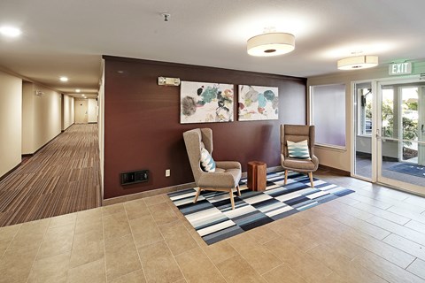 a lobby with two chairs and a rug at Townside Flats, Redmond, 98052