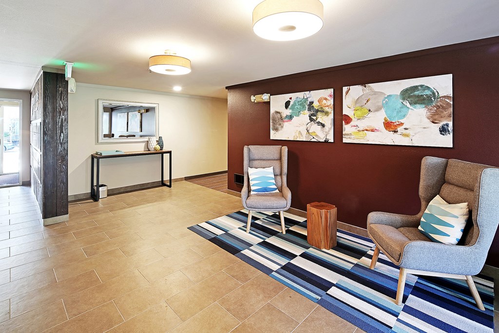a lobby with two chairs and a rug and a table  at Townside Flats, Washington, 98052