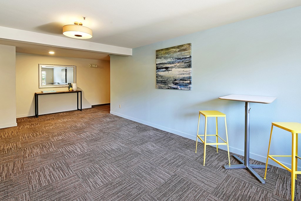 a community room with stools and a counter with a mirror  at Townside Flats, Redmond, Washington