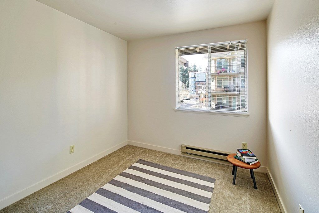 an empty room with a rug and a window  at Townside Flats, Redmond, 98052