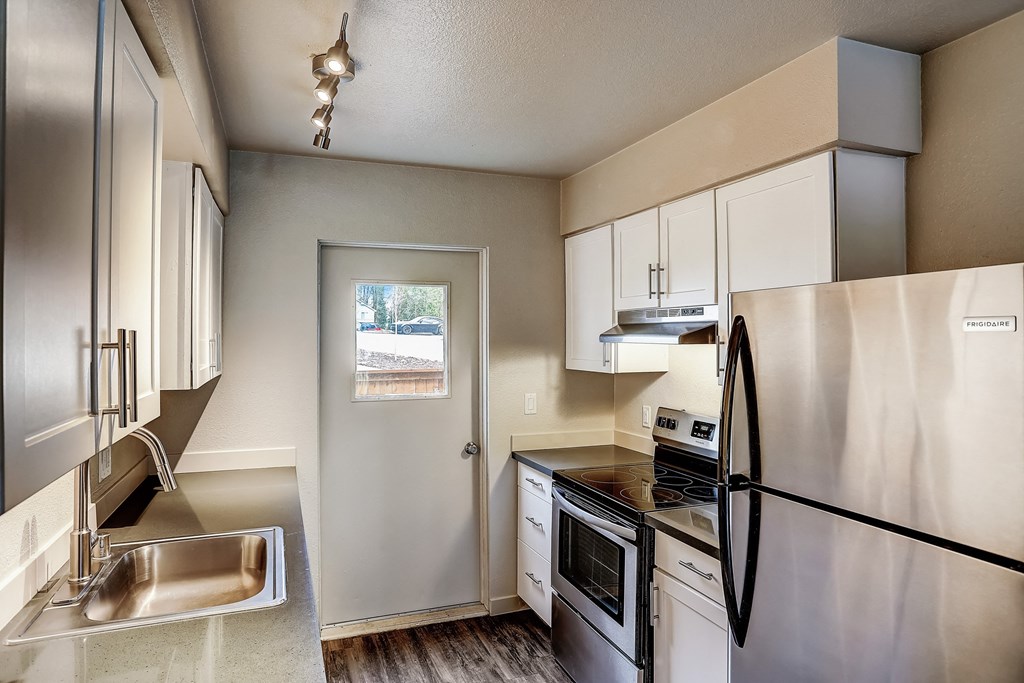 a kitchen with stainless steel appliances and white cabinets at Woodcreek, Poulsbo, WA