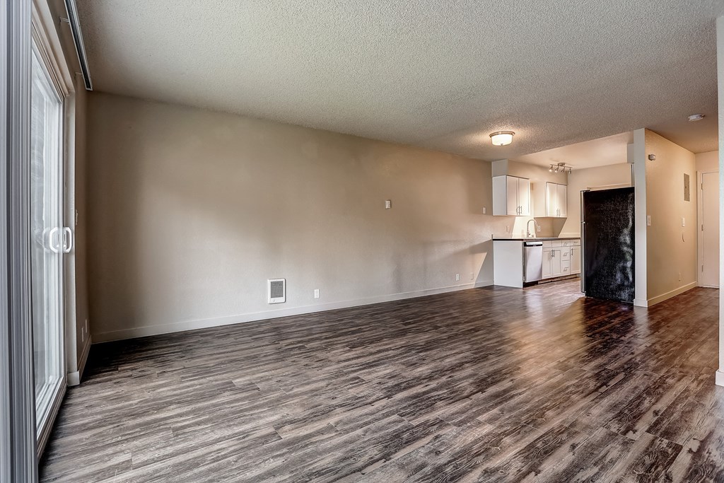the living room and kitchen of an apartment with wood flooring at Woodcreek, Poulsbo