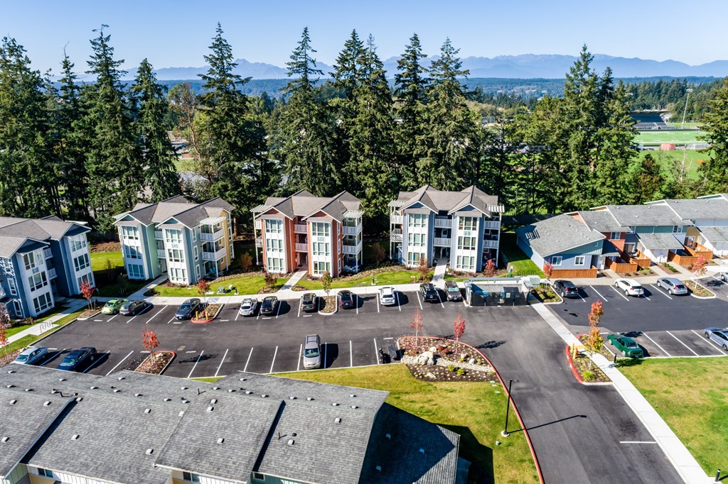 an aerial view of an apartment complex with parking lot and trees at Woodcreek, Washington, 98370