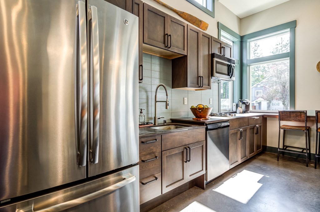 a kitchen with stainless steel appliances and wooden cabinets at Woodcreek, Poulsbo, WA 98370