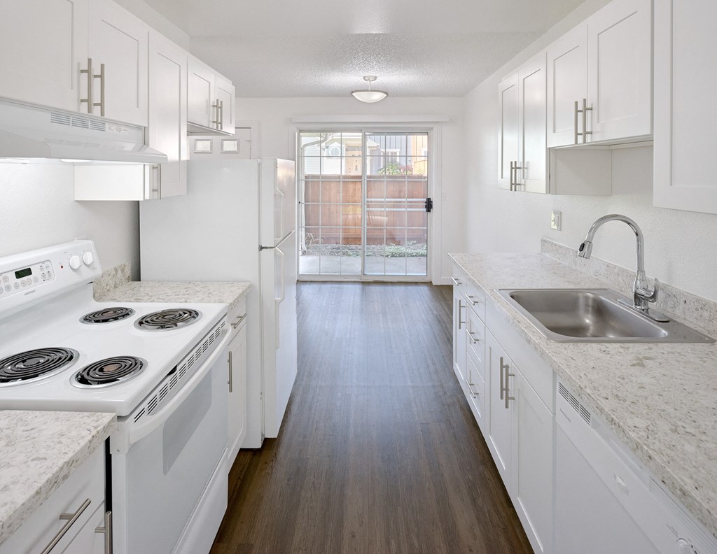 an empty kitchen with white cabinets and white appliances and a sink at Woodcreek, Washington, 98370
