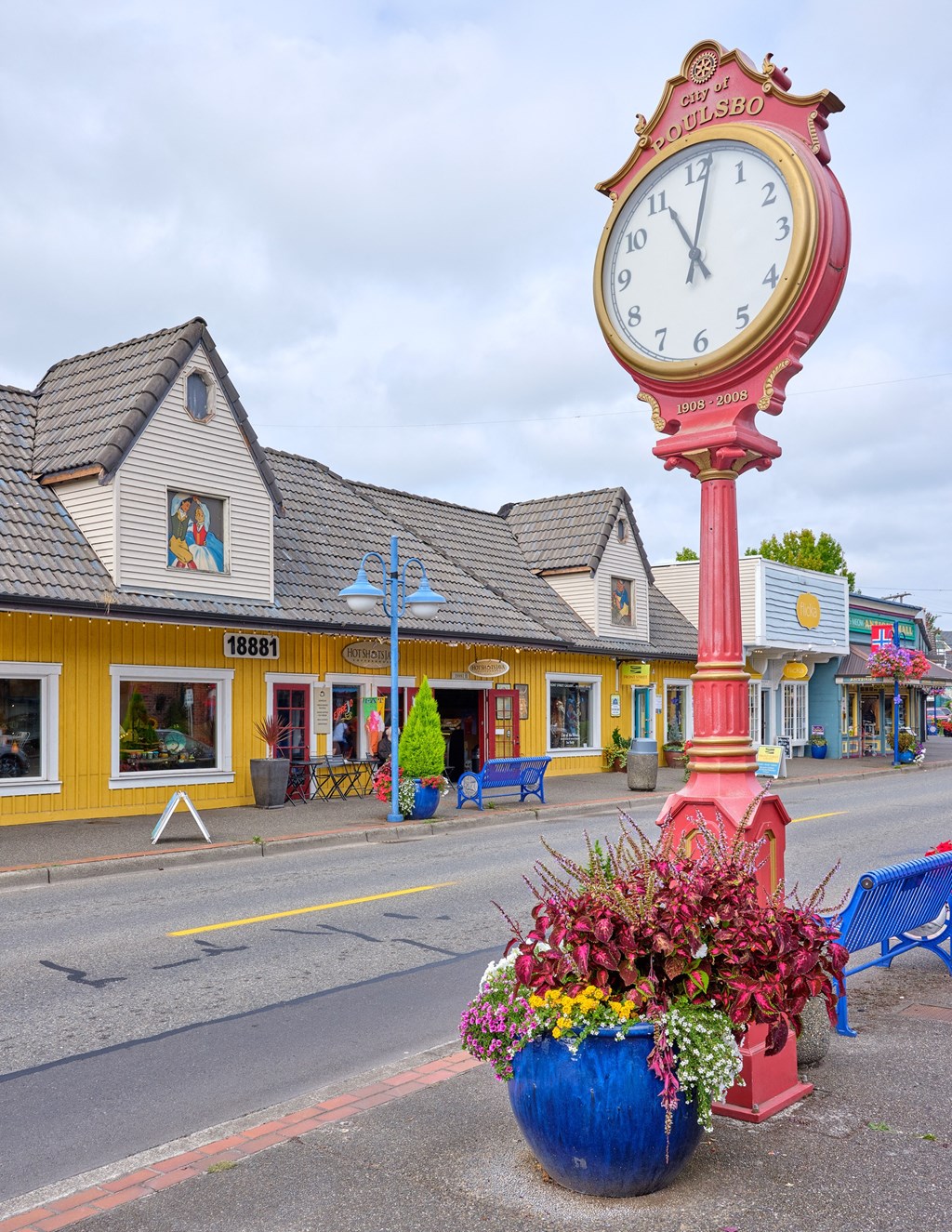 a large clock on the side of a street with a vase of flowers at Woodcreek, Washington, 98370