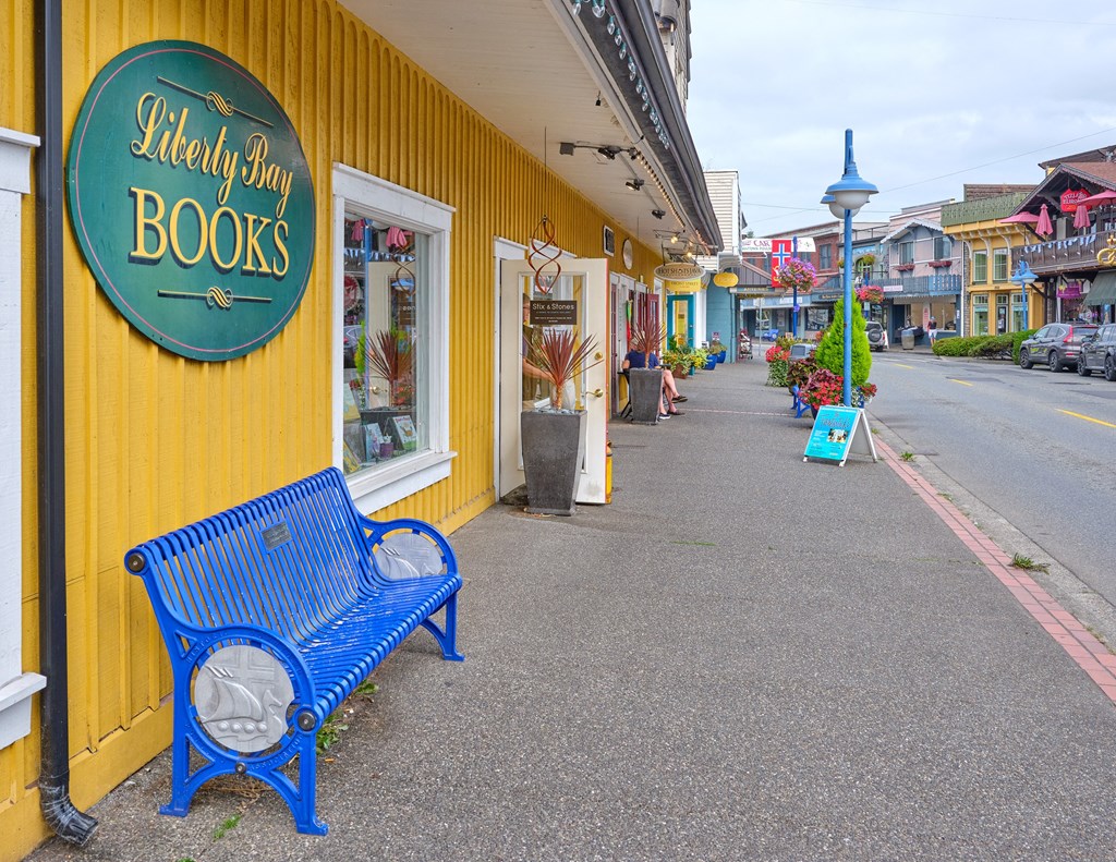 a blue bench in front of a yellow building at Woodcreek, Poulsbo, WA 98370