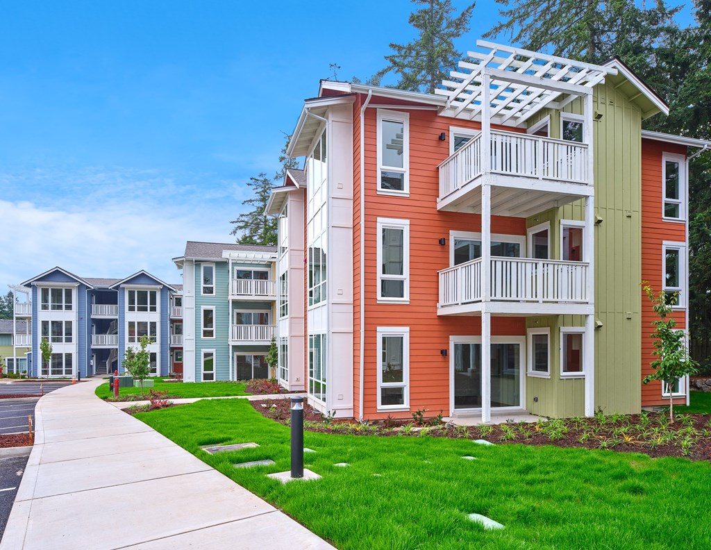 an apartment building with a sidewalk in front of it at Woodcreek, Poulsbo