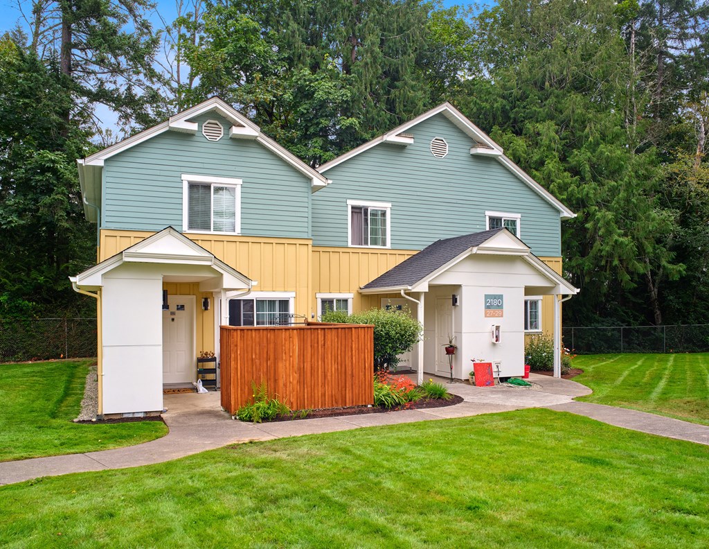 a blue and yellow house with a yard and a wooden fence at Woodcreek, Washington, 98370