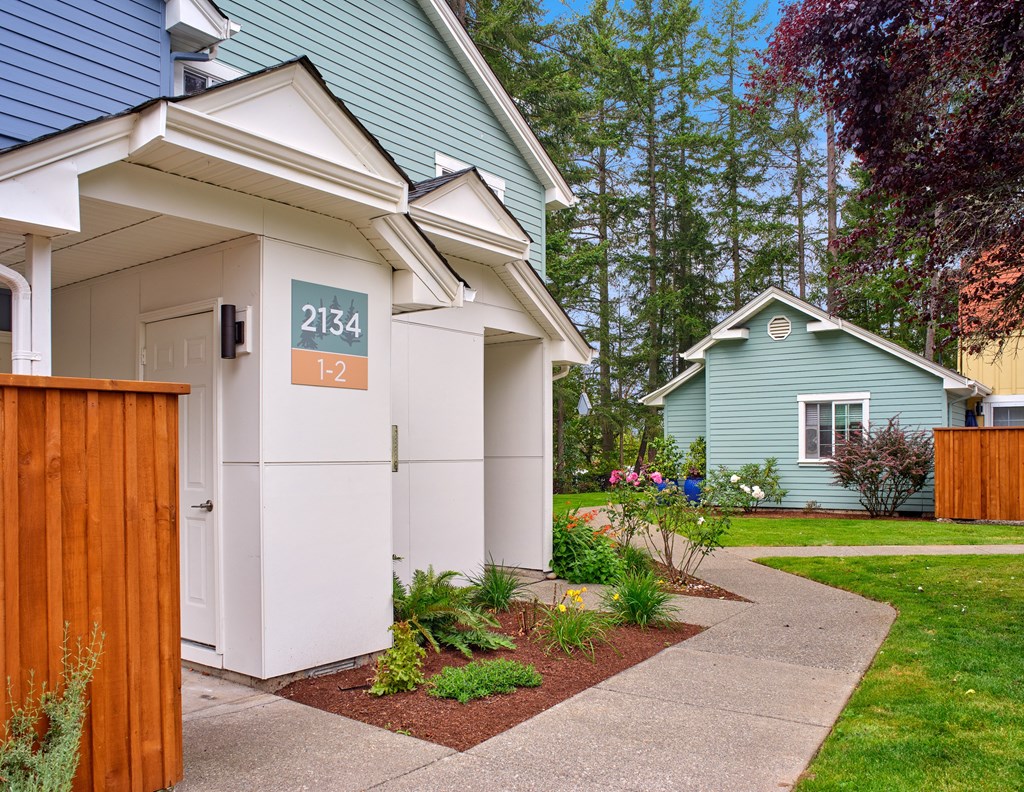 a white and blue house with a sidewalk in front of it at Woodcreek, Poulsbo Washington