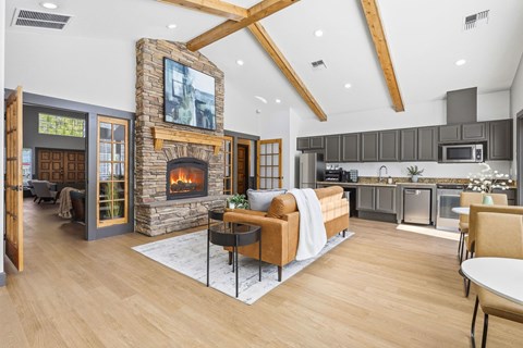 A modern living room with a stone fireplace and a flat screen TV mounted above it.