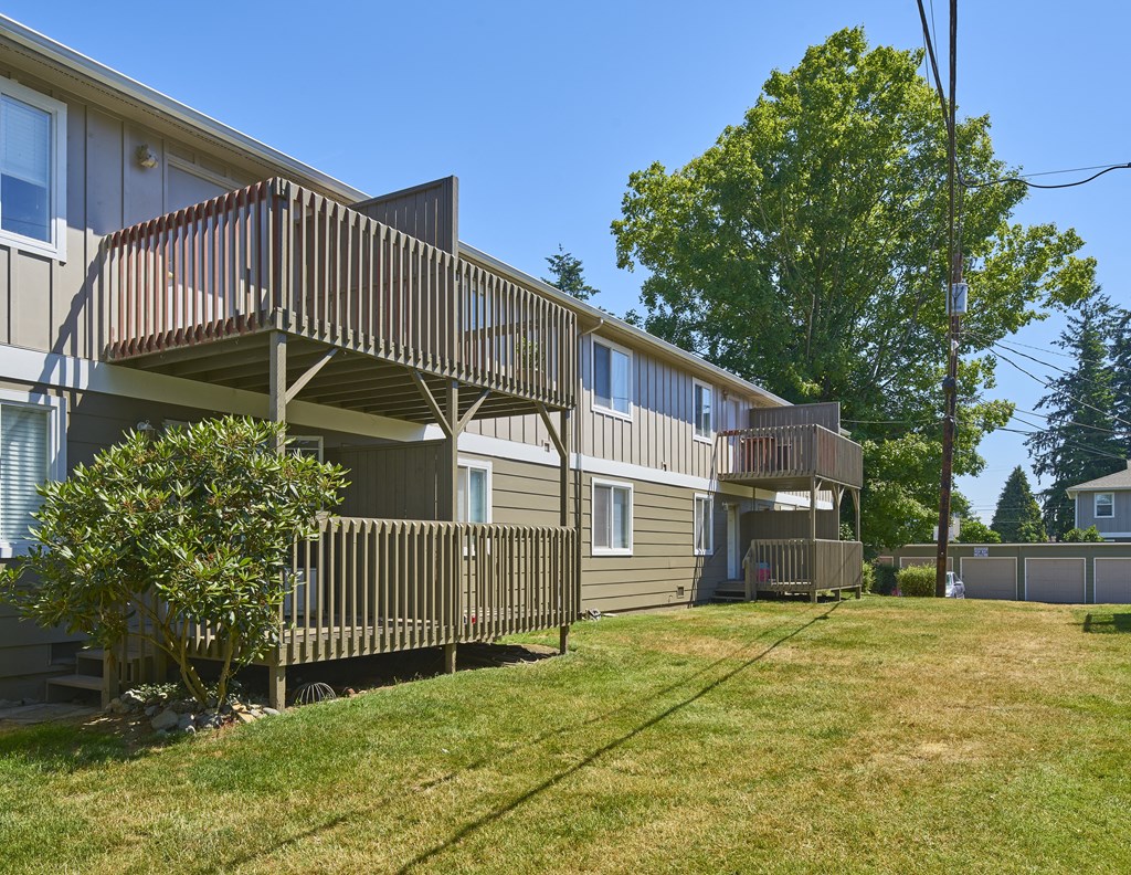 the back of two houses with balconies and a grass yard  at Woodhaven, Washington, 98203
