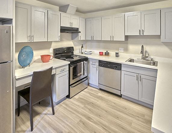 a kitchen with white cabinets and stainless steel appliances - Photo Gallery