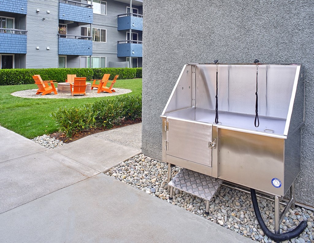 a stainless steel dog wash station sits on the side of a sidewalk in front of an apartment building  at 3030 Lake City, Seattle