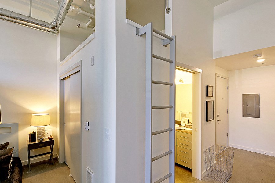 Loft apartment with vaulted ceilings. Staged bedroom on the left and a hallway to the kitchen and bathroom on the right.at 19th & Mercer, Washington, 98112