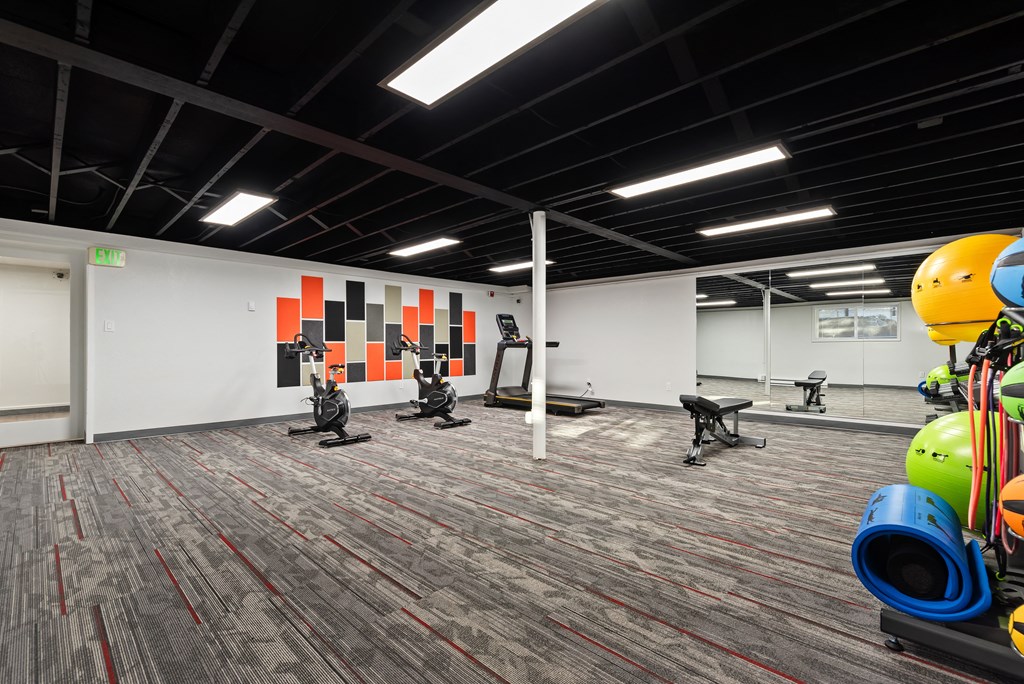 a workout room with exercise equipment and weights in a building with white walls and carpet at Talavera in Boise, ID