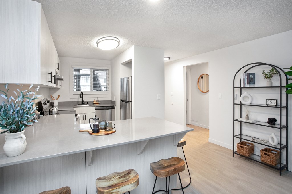 an open kitchen with a white counter top and a large island with two stools at Brix, Washington, 99362