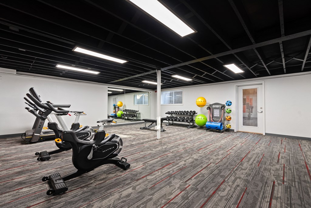 a workout room with exercise equipment and weights in a building with white walls and carpet at Talavera in Boise, ID