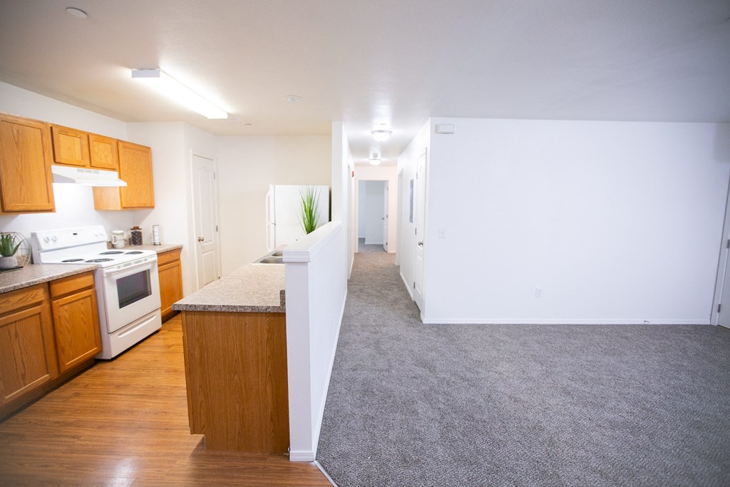 an empty kitchen and living room with wood floors and white walls  at Canyon View, Idaho, 83501