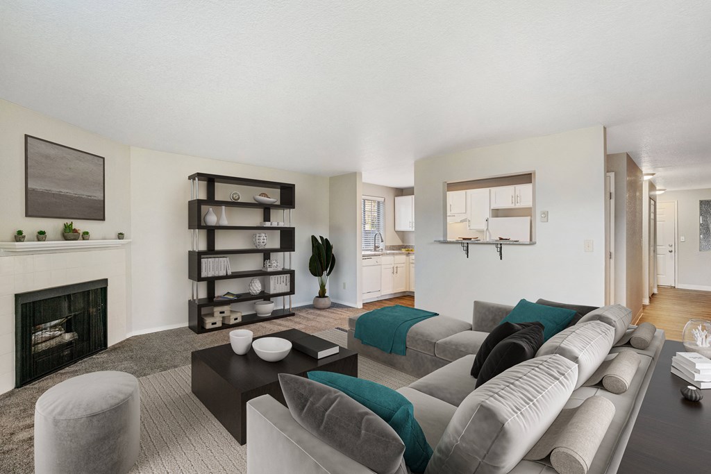 Carpeted living room, gas fireplace, and mantle on the left, with door and pass-through to kitchen area at Capitol Crossing, Olympia, WA