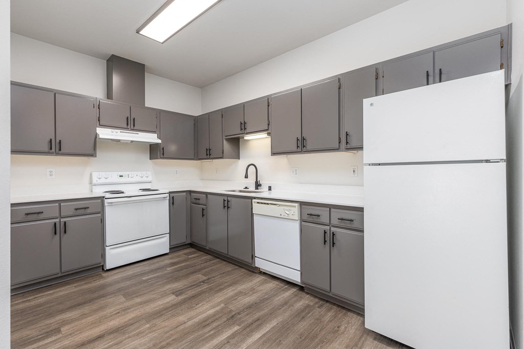 a large kitchen with white appliances and gray cabinets  at Shoreline Village, Richland, 99352