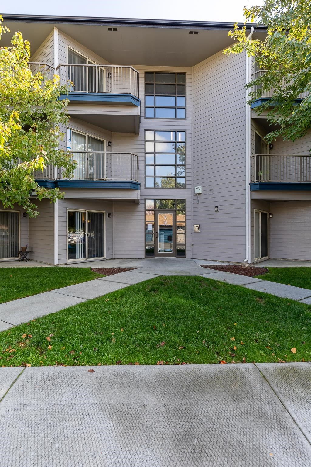 an exterior view of an apartment building with a sidewalk and grass  at Shoreline Village, Richland