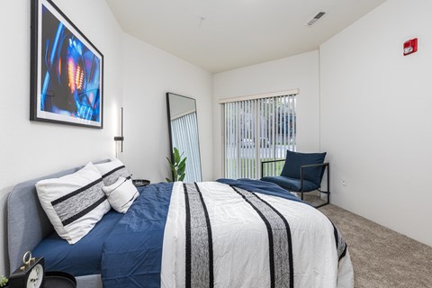 a bedroom with a blue and white bed and a chair  at Shoreline Village, Richland