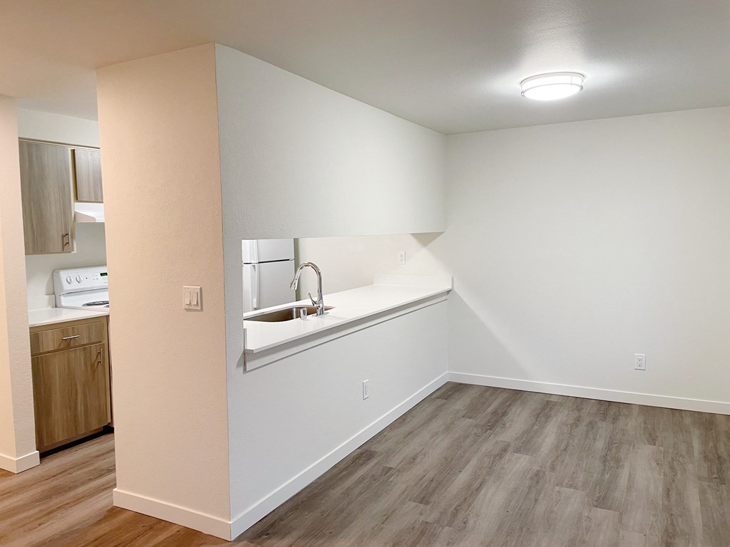 Dining area with wood-style flooring to the right, and the kitchen with a pass through window to the left.at The Trail, Washington